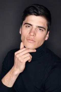 One young handsome man, model wearing turtleneck, simple studio upper body sh Stock Photos