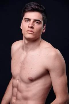 One young handsome man, model shirtless, simple studio upper body shot, black Stock Photos