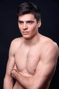 One young handsome man, model shirtless, simple studio upper body shot, black Stock Photos