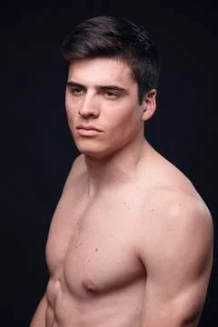 One young handsome man, model shirtless, simple studio upper body shot, black Stock Photos