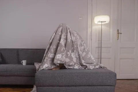 One young man, beneath bed sheets hiding Stock Photos