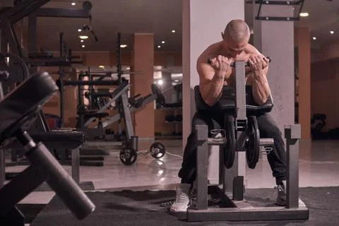 One young man bodybuilder, exercise equipment, bicep curl, indoors gym. full  Stock Photos