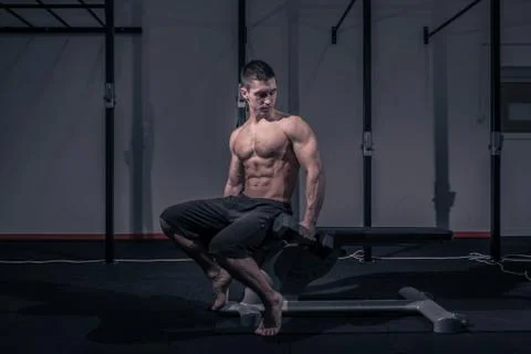 One young man, bodybuilder posing, holding dumbbells Stock Photos