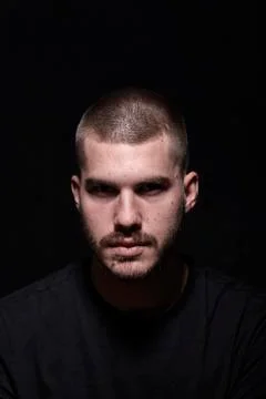One young man, dark dramatic scary eyes, head and shoulders shot. looking at  Stock Photos