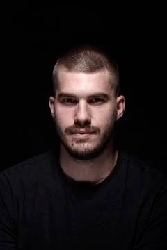One young man, dramatic portrait. black background. head and shoulders shot.  Stock Photos