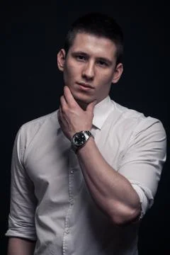 One young man, hand touching face,black background Stock Photos