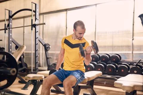 One young man, looking down sideways, sport clothes, in old beaten up gym ind Stock Photos
