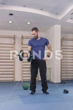 One young man only, muscular exercise one dumbbell Stock Photos