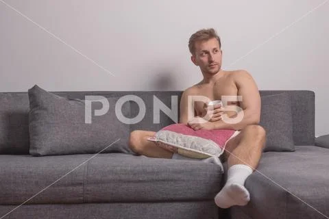 One young man only, sitting sofa bed pillows Stock Photos