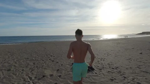 One young man running and enjoying summer in a beach alone with sunset Vídeos de archivo 143362807