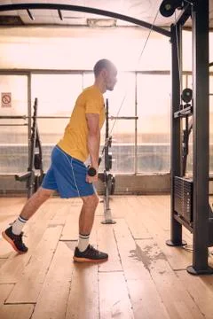 One young man, serious expression, wearing sport clothes, exercise on resista Stock Photos