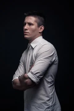 One young man, side view, looking tense, black background Stock Photos
