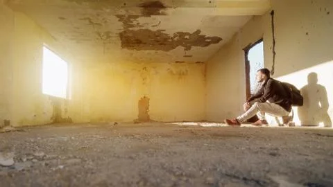 One young man sitting in empty ruined room Stock Photos