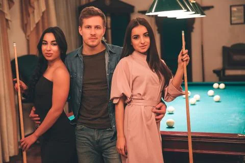 One young man stand beyween two models. They look on camera seriously. Young Stock Photos