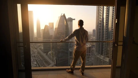 One Young Man Standing on Office Balcony Overlooking City Skyline Stock Footage 103588296