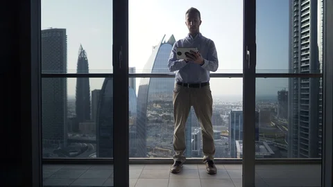 One Young Man Standing on Office Balcony Overlooking City Skyline Stock Footage 103588338