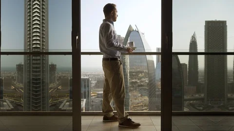 One Young Man Standing on Office Balcony Overlooking City Skyline Stock Footage 103588352