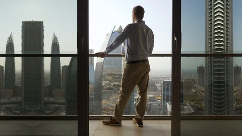 One Young Man Standing on Office Balcony Overlooking City Skyline Stock Footage 103588394