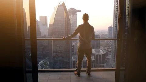 One Young Man Standing on Office Balcony Overlooking City Skyline Stock Footage 103588515