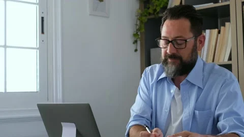 One young man working at home in the office with laptop and notebook taking note Stock Footage 151322277