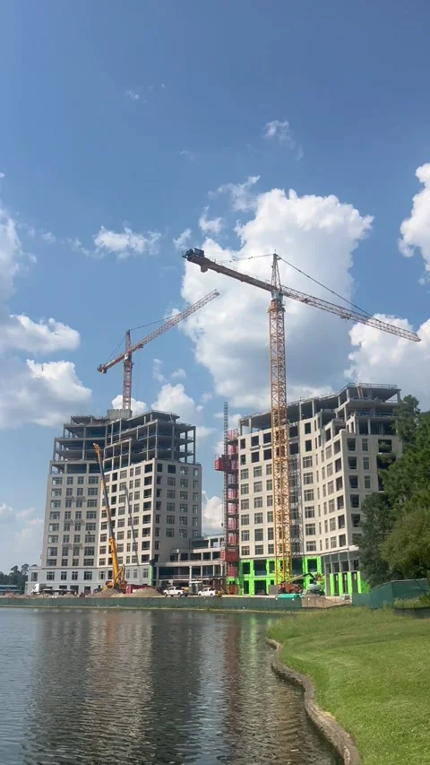 Ongoing construction of two buildings in front of a beautiful lake Stock Footage 337265398