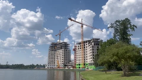 Ongoing construction of two buildings in front of a beautiful lake Stock Footage 337265479