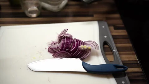 Onion cut into thin rings lies on a cutting board on the table Stock Footage 266778087