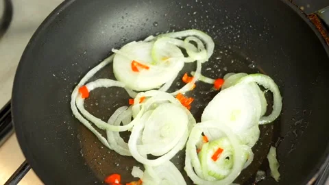 Onion fried in the pot with chunks of red pepper. Video stock 151153902