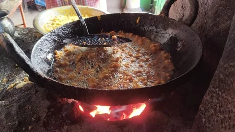 Onion pakoras are being deep-fried in a large iron pan. 库存影片 330416693