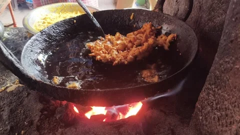 Onion pakoras are being deep-fried in a large iron pan. 库存影片 330416710