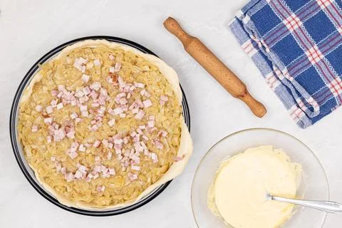 Onion Pie with sliced Bacon on the table ready for baking Stock Photos