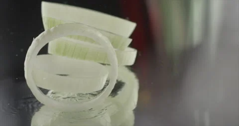 Onion ring fall on a mirror area Stock Footage 200254804