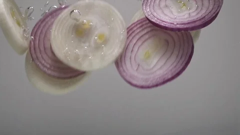 Onion rings fall into the water. Video stock 124520563
