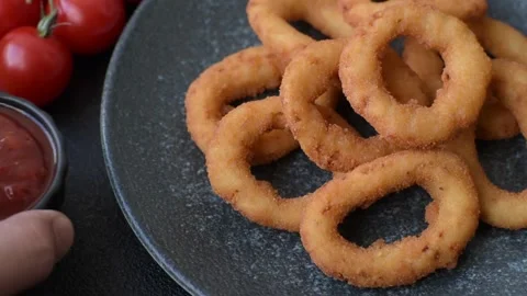 Onion rings or fried squid in breadcrumbs with sauce, takeaway food. Onion rings Stock Footage 318577624