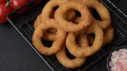 Onion rings or fried squid in breadcrumbs with sauce, takeaway food. Onion rings Stock Footage 318577633