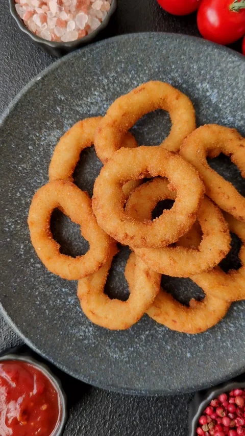 Onion rings or fried squid in breadcrumbs with sauce, takeaway food. Onion rings Stock Footage 318577714