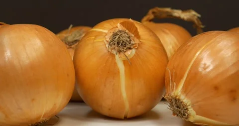 Onion rotates on brown background, close-up shot Stock Footage 309646433