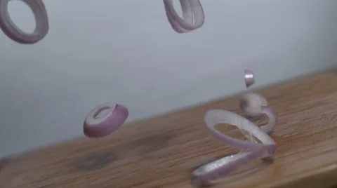 Onion slices falling in concentric rings onto a cutting board - slow motion Stock Footage 64666285
