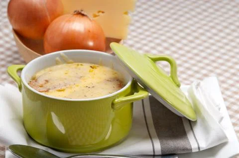 Onion soup with melted cheese and bread on top Stock Photos