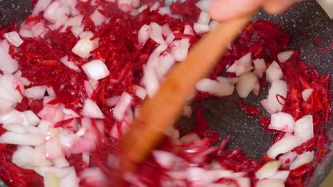 Onions and beetroot are fried in a frying pan Stock Footage 255125902