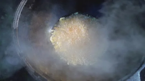 Onions are fried over high heat in a cauldron Видео 250170710