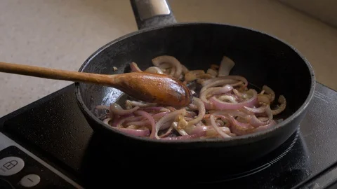 Onions are fried in a pan. Close-up. Stock Footage 112975485