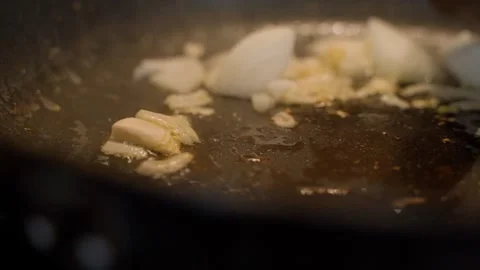 Onions are fried in a pan, close-up. Stirring the onions with a wooden spatula Video stock 311796809