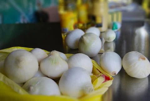 Onions in bag on table Stock Photos