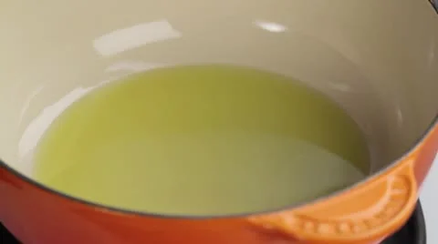 Onions being added to a oil in a saucepan Stock Footage 24656830