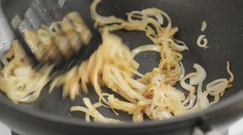 Onions being fried and curry paste being stirred in Stock Footage 24653249