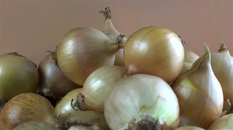 Onions isolated rotating on brown background Video stock 62388258