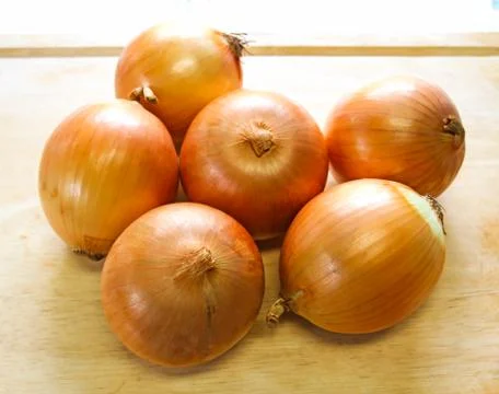 Onions on a kitchen cutting board Stock Photos