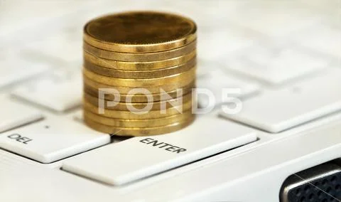 Online business success - money coins on a white computer keyboard Stock Photos