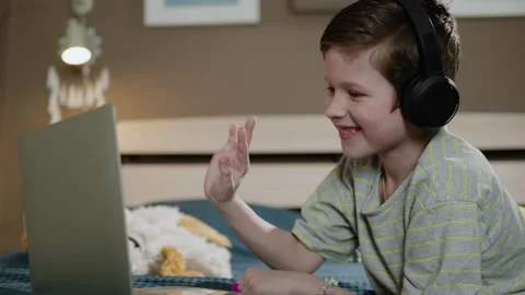 Online conversation. Boy in headphones looking at laptop and waving hello Vídeos de archivo 307170553